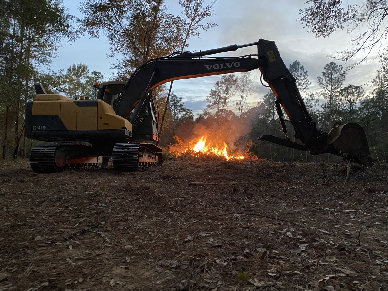 Dirt pile next to an open trench with utility pipes.